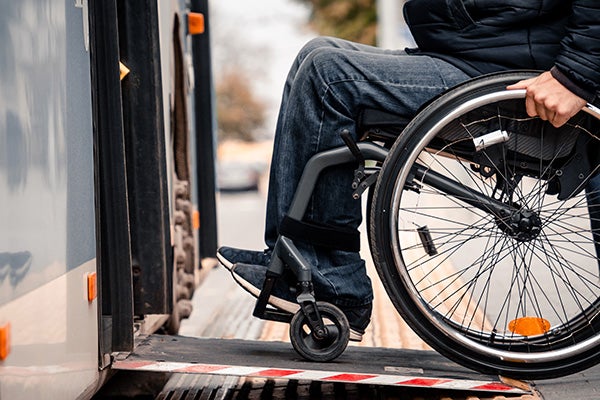 person in wheelchair entering tran with ramp